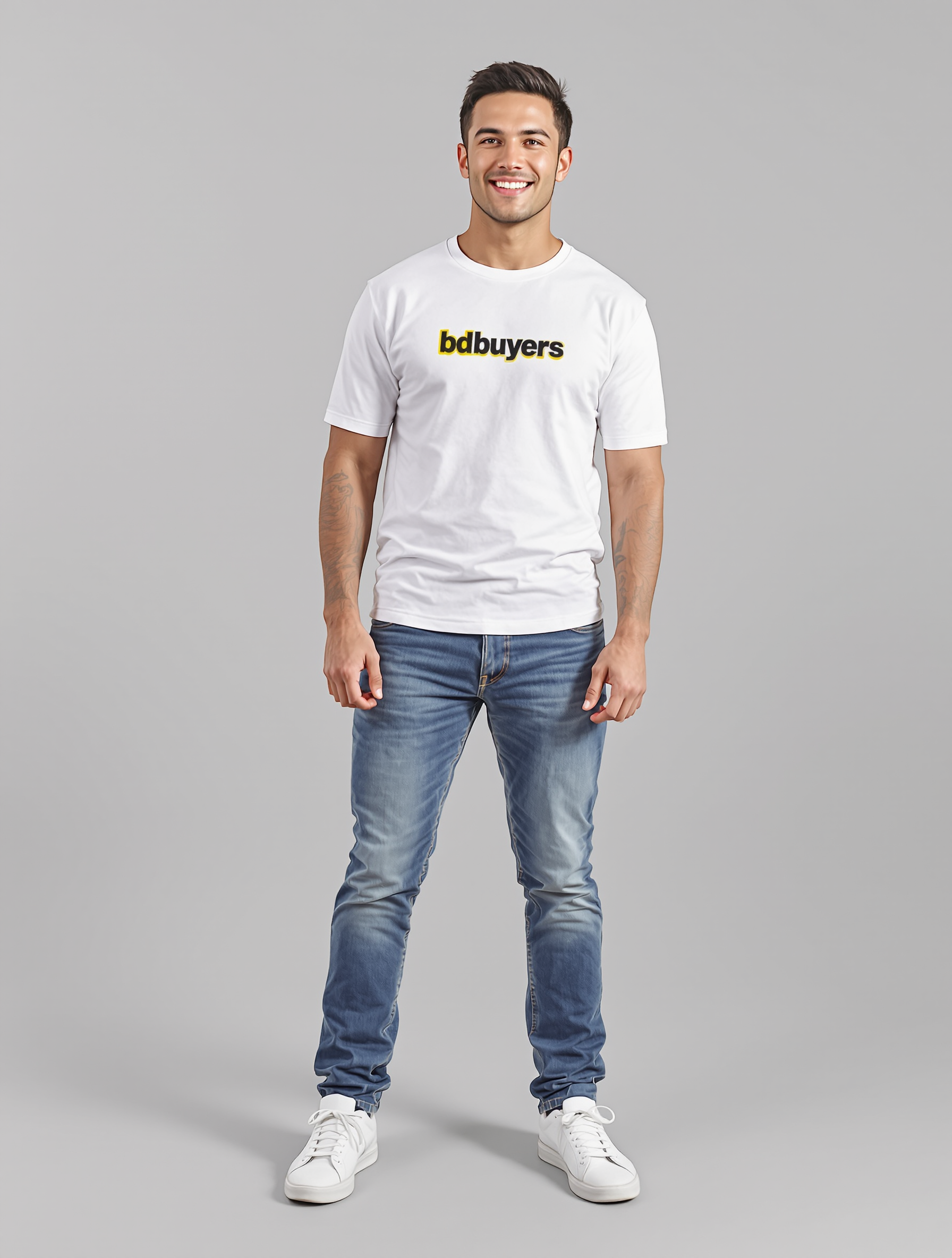 Man in white t-shirt with logo and blue jeans standing against gray background