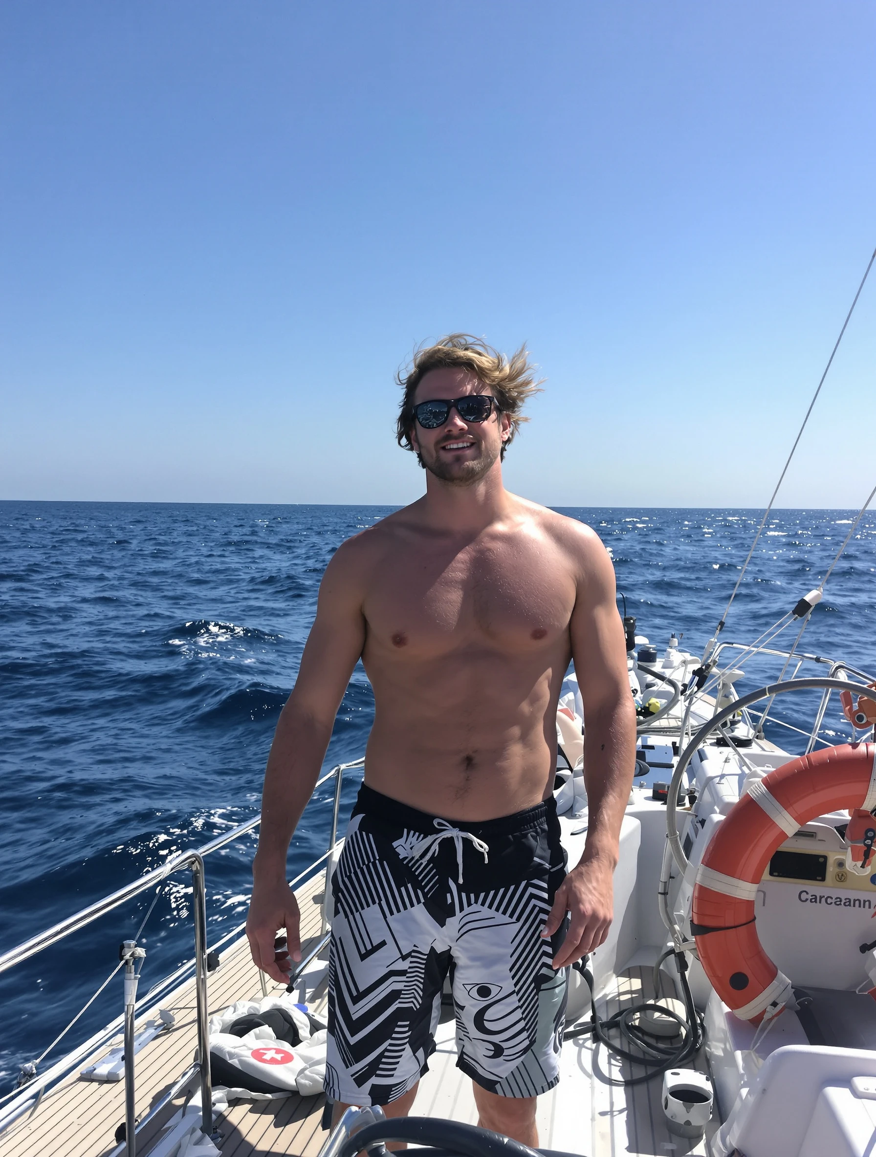 Man on a yacht deck enjoying ocean sailing, shirtless in the sun. Nautical swim shorts, athletic build, wind in hair, luxury boat lifestyle.
