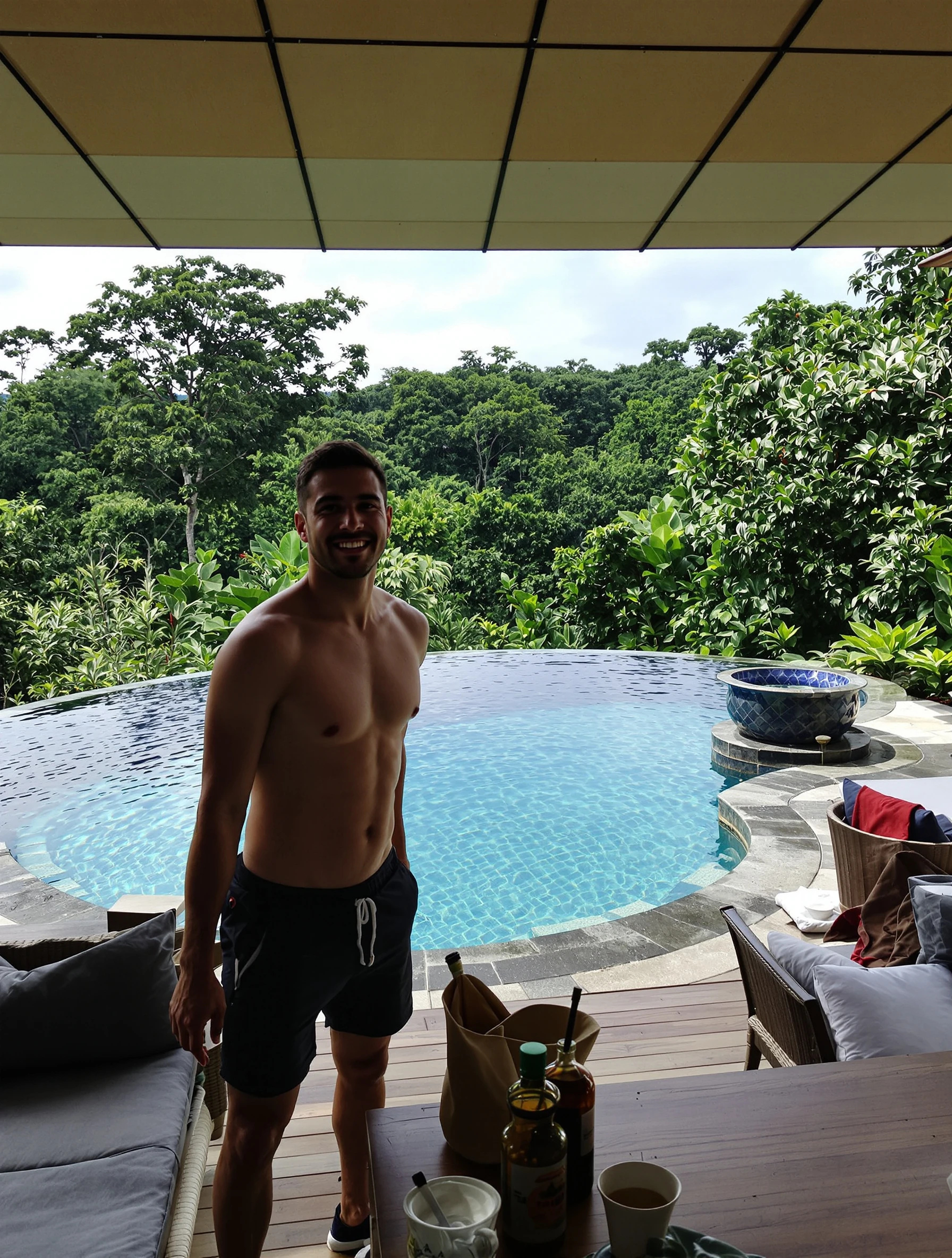 Man at luxury Bali villa with infinity pool and jungle views. Relaxed vacation style, tropical paradise, dream accommodation, island living.