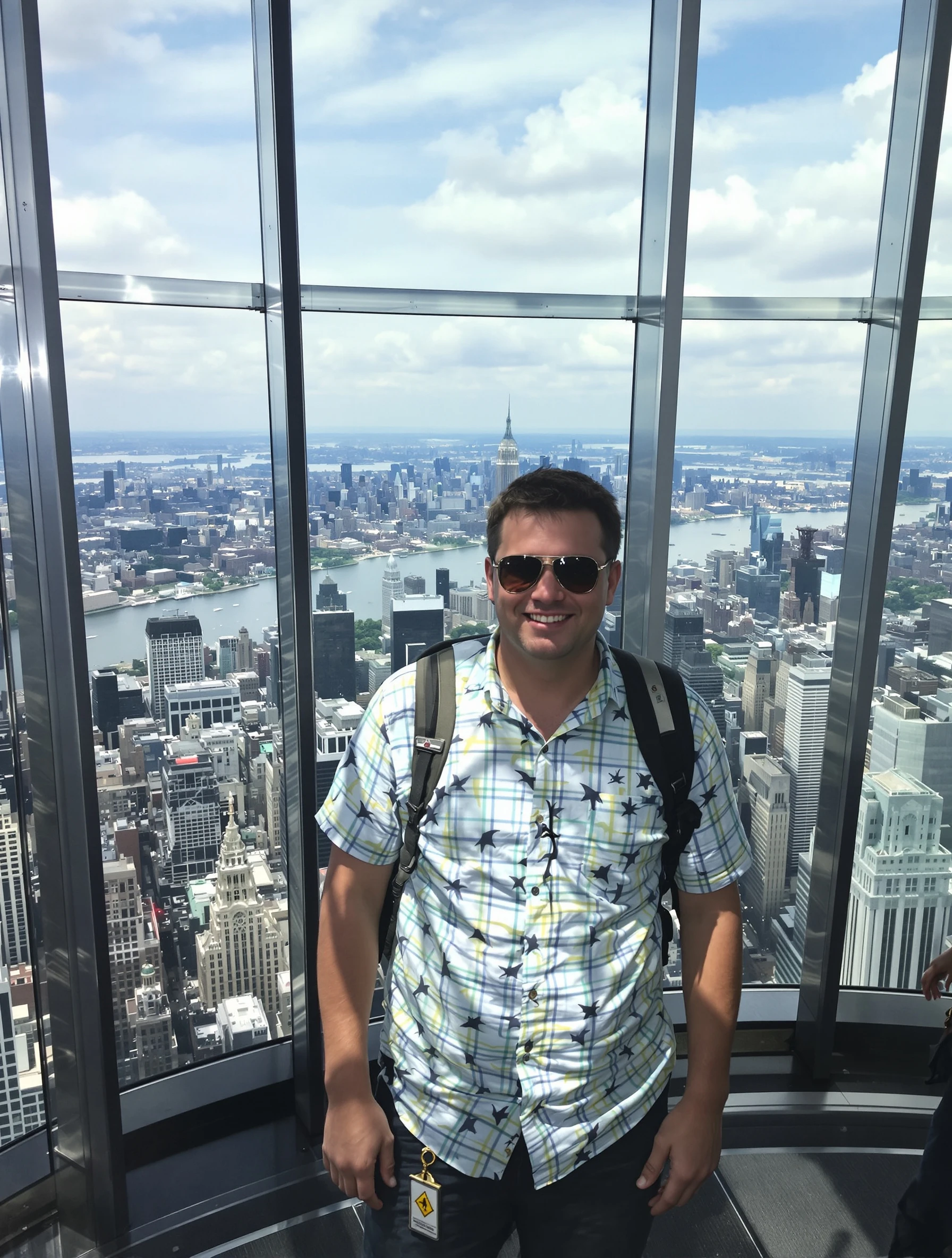 Man at Empire State Building observation deck, city spreading below. Tourist casual, panoramic NYC views, top of the wor